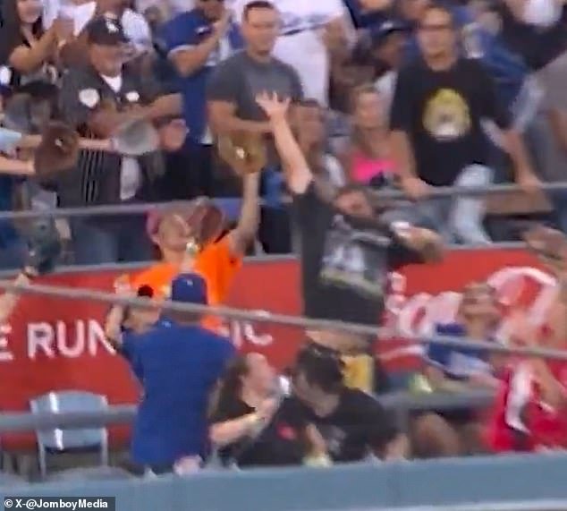 103450239-15241049-The_fan_in_the_orange_t_shirt_caught_Vlad_Guerrero_Jr_s_home_run-a-4_1761840786849.jpg