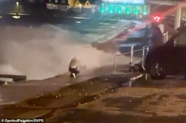 En este momento, una adolescente casi es arrastrada hacia el mar mientras se toma una SELFIE en un muro del puerto durante la tormenta Ingrid mientras el clima arrasa el muelle histórico y golpea la costa.